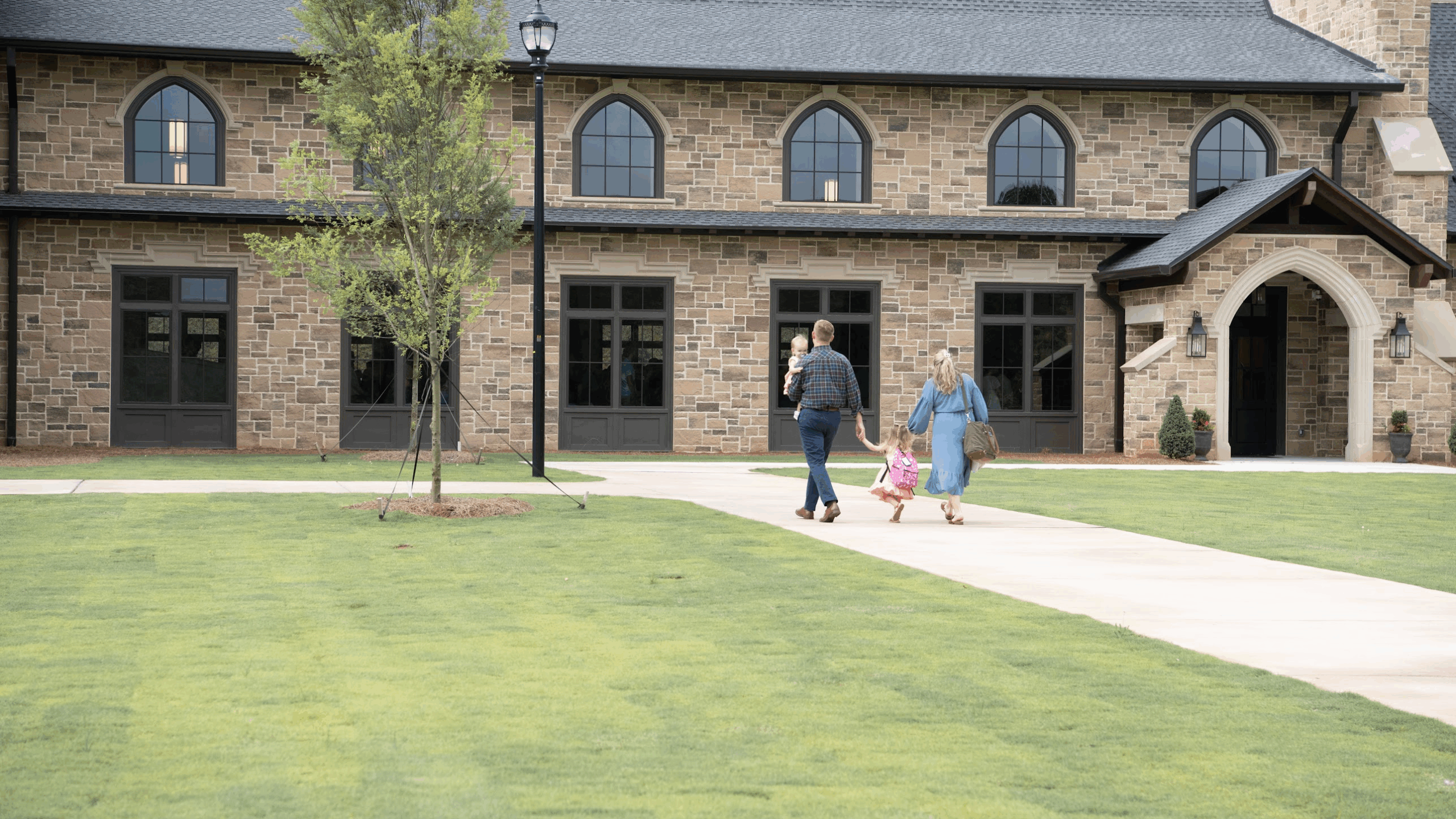 young family walking to building